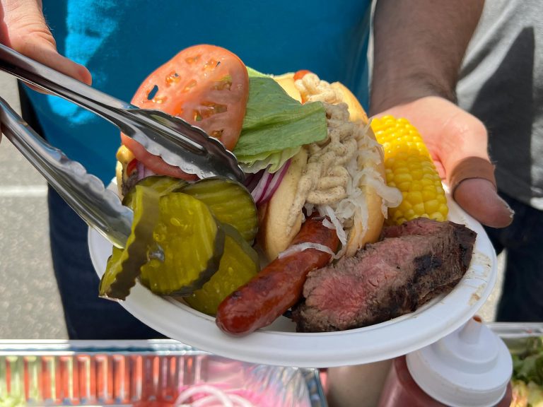 Close up of hot dog, steak, and corn on the cob at a barbecue